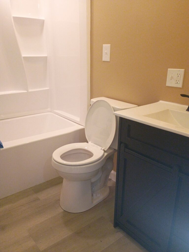 Bathroom with tub, vanity and wood-look flooring